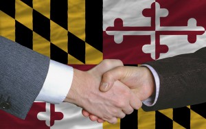 in front of american state flag of maryland two businessmen hand