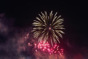 Bright Red Fireworks Lights In The Night Sky. Small City Celebra