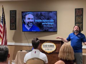 man presenting at meeting with tv