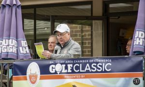 man speaking in microphone and golf event