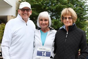 two women and one man standing outside for run