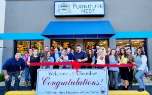 Ribbon cutting with a group of people outside a furniture store