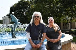 man and woman sitting by outdoor fountain