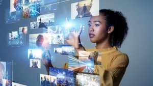 Girl in yellow sweater looking at images on a glass screen