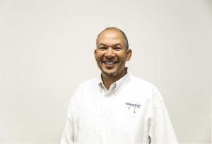 headshot of man wearing white telewire shirt