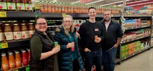 Group of 4 people standing in a soda aisle