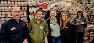 Owner of grocery store tanding with three smiling girls