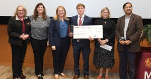 Six people holding a large check