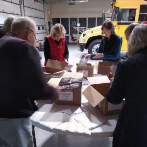 group of people organizing books in boxes