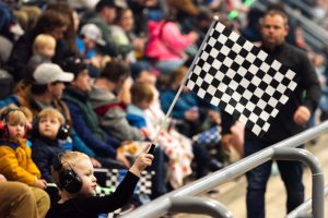 kid holding flag near audience at event