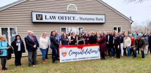 Group of people cutting a large ribbon outside a law office