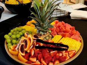 Plate of fruit with pineapple leaf in the middle