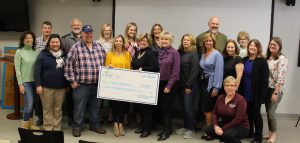 group of people holding large check