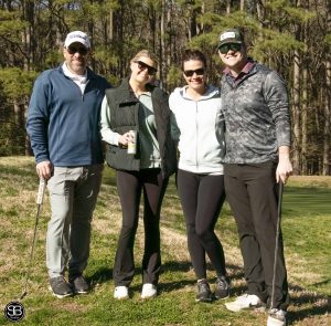 group of 4 people standing on golf course
