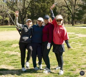 4 women standing on golf course