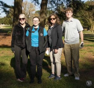 4 people standing together on golf course