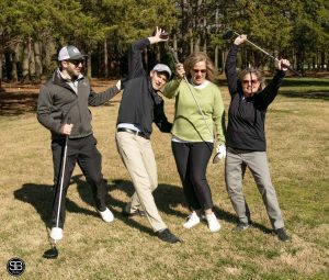 4 golfers doing funny poses on golf course