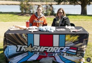 two women sitting at table with Trashforce banner