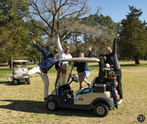 golfers standing on golf cart