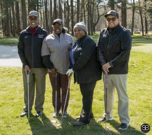 group of people standing on golf course