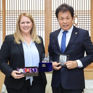 woman and man standing together holding awards