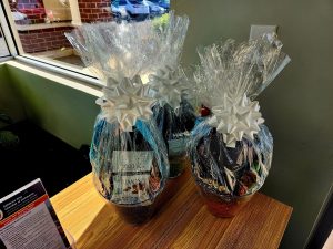 3 gift baskets with white bows on table