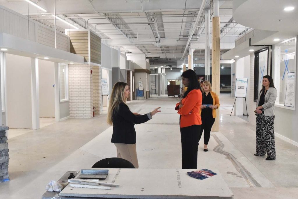 people standing in hallway of college under construction