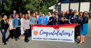 group of people standing behind congratulations banner