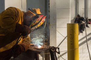 student practices welding in class