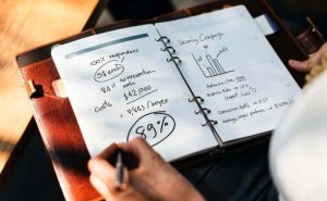 close up of person writing calculations on notepad