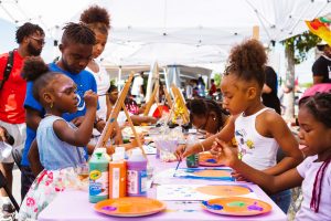 children sitting together at event painting