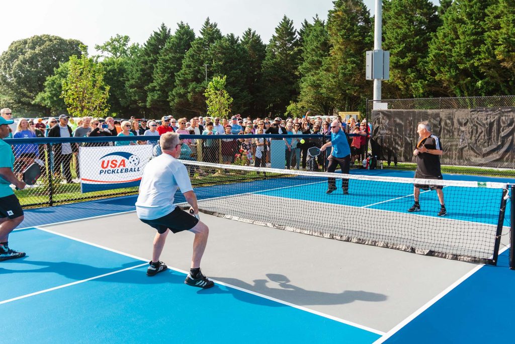 people watch group playing pickleball