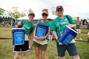 three volunteers at maryland folk festival holding donation buckets
