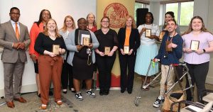 group of people standing together holding awards