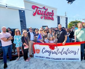 group of people standing outside Taylor's BBQ for ribbon cutting