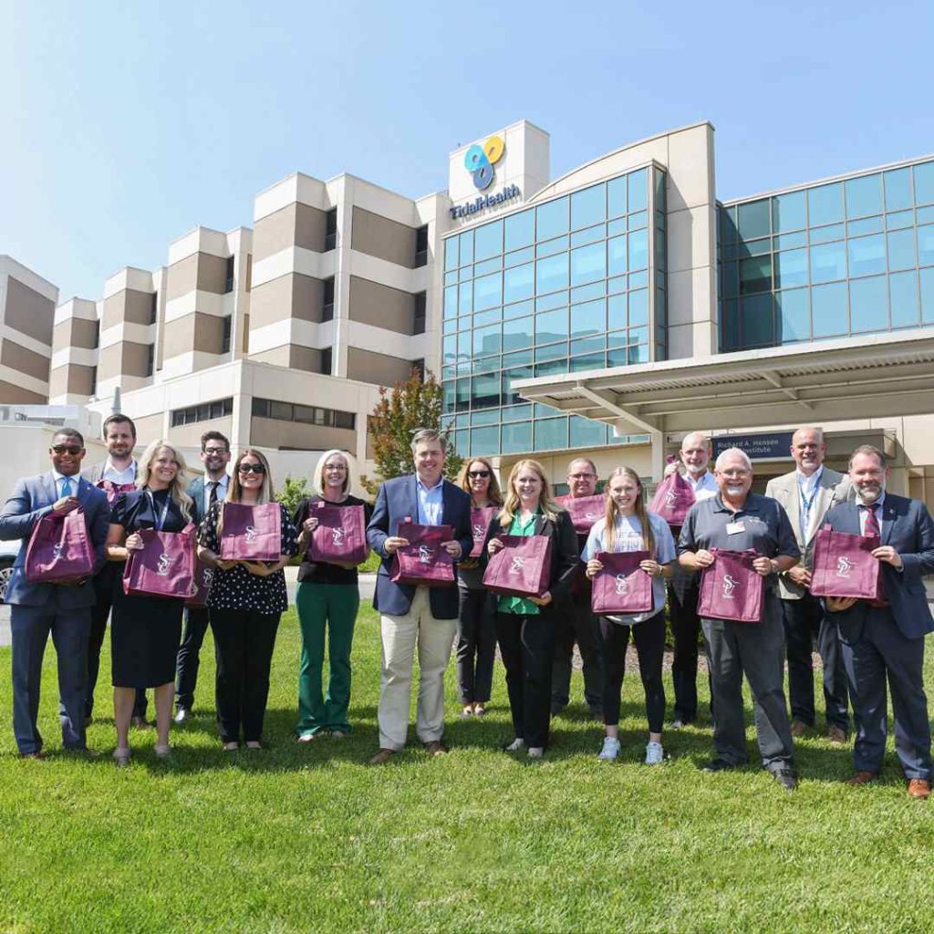 team standing outside TidalHealth hospital holding cancer kits