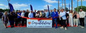 Group of people standing behind a congratulations sign with a ribbon