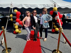 Three women posing on a red carpet