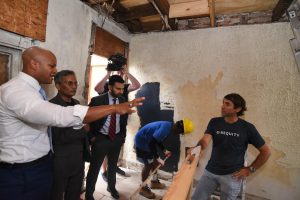 governor moore standing inside old townhome with workers