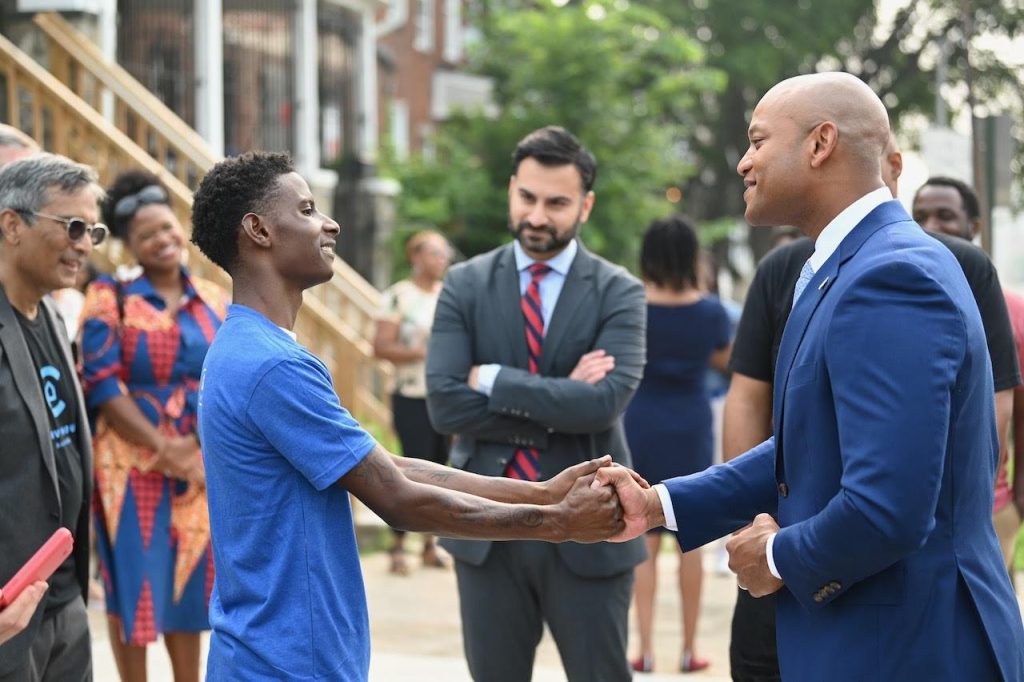 governor moore shaking hands with baltimore resident