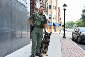 officer standing on sidewalk with dog