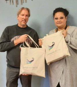 man and woman holding Unstoppable Joy handbags