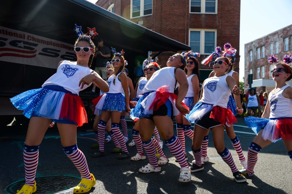 softball team dressed up in red white and blue outside