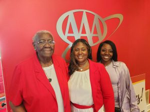 three ladies standing in front of AAA sign