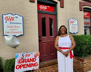 lady standing out side of AAA insurance Grand Opening sign