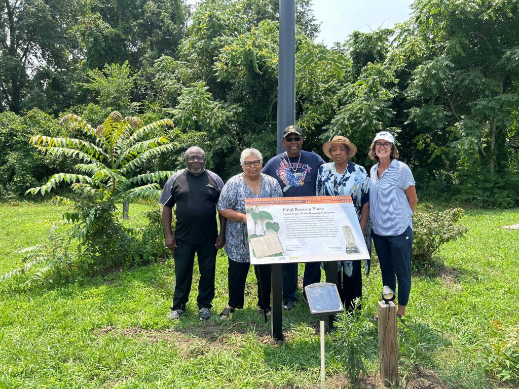 group of people standing outside by sign