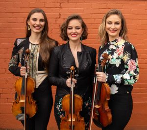 three female band members holding violins