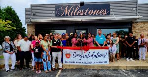 group of people standing outside at ribbon cutting