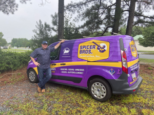 Man leaning on a purple work van