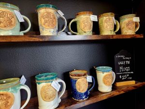 close up of ugly pie mugs on shelves